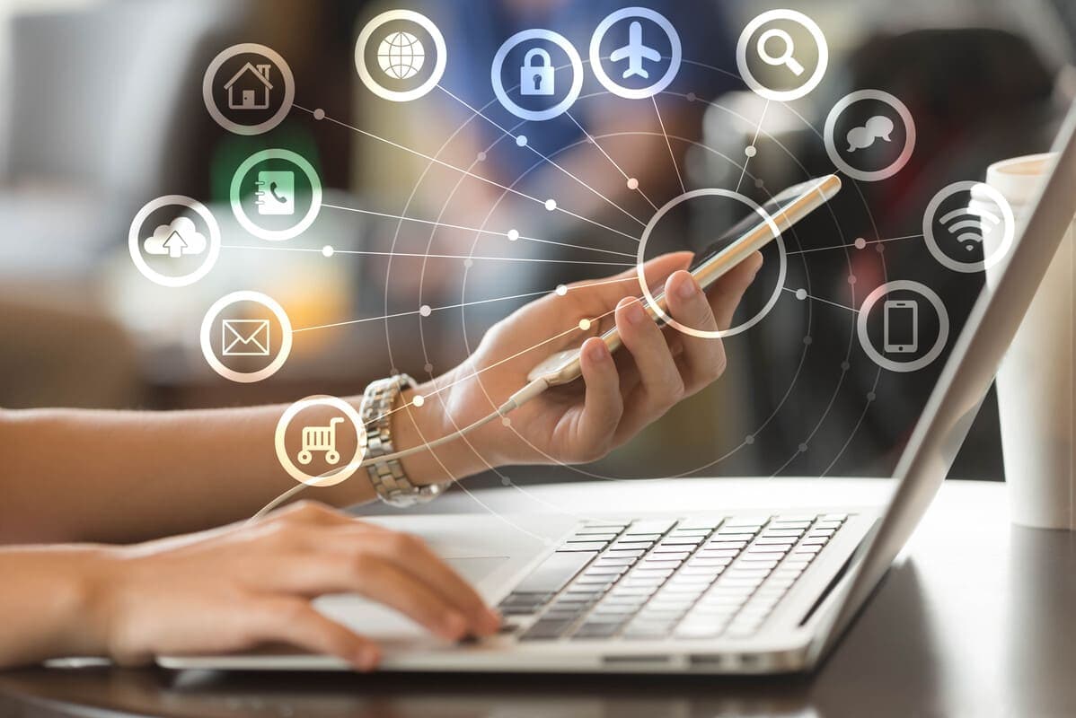 Freelancer trabalhando pelo celular e notebook, renda extra na internet comparada ao CLT